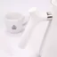 White electric kettle, detail on the kettle handle, with a cup of coffee in the background.