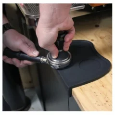 Rubber corner pad on a wooden table during the coffee distribution process in the portafilter