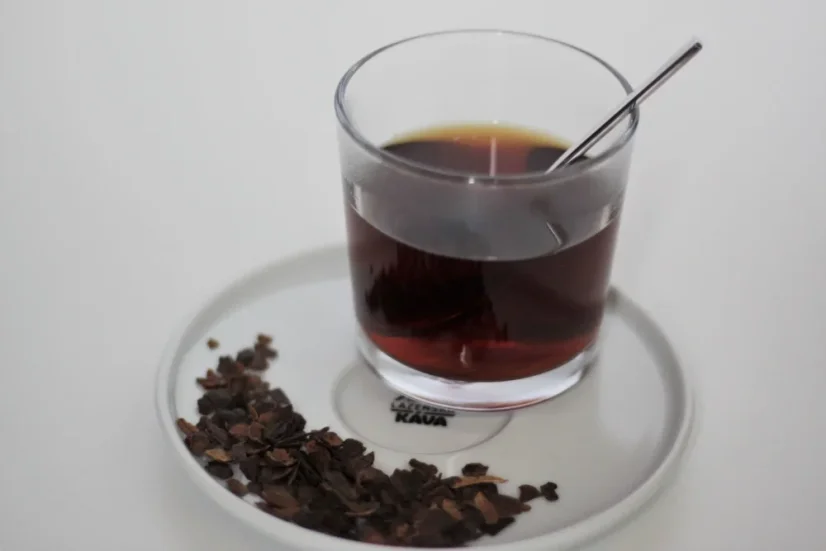 Cascara in a glass with a spoon on a saucer.