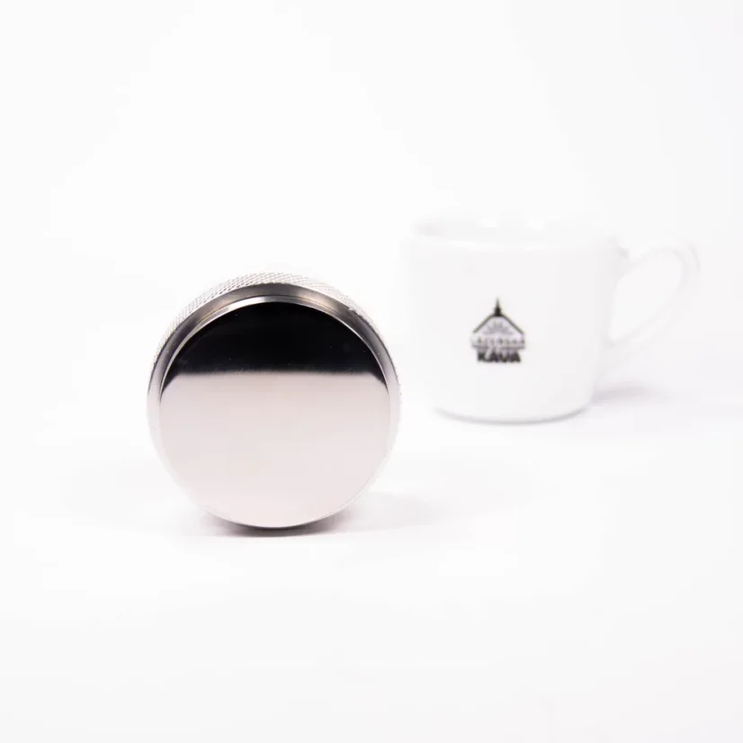 Detailed view of Rocket Espresso distributor and tamper 58mm in silver with coffee.