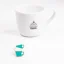 Insigne bleu à côté d'une tasse de café.