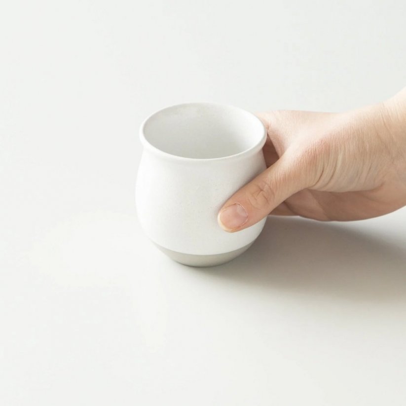 Fehér Origami Pinot Flavor szűrő kávés bögre a kezében.
