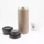 View of an unfolded khaki Kino Travel Tumbler Khaki 350 ml with a cup featuring coffee motifs in the background.