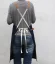 Baristische Schürze in Jeansblau mit Modell, Ansicht von hinten Baristische Schürze in Jeansblau mit Modell, Ansicht von hinten
