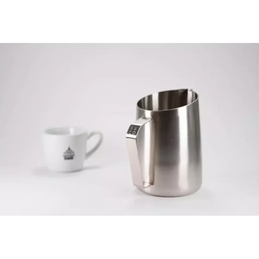 Pichet à lait d'une capacité de 600 ml avec une tasse en porcelaine sur une table blanche.