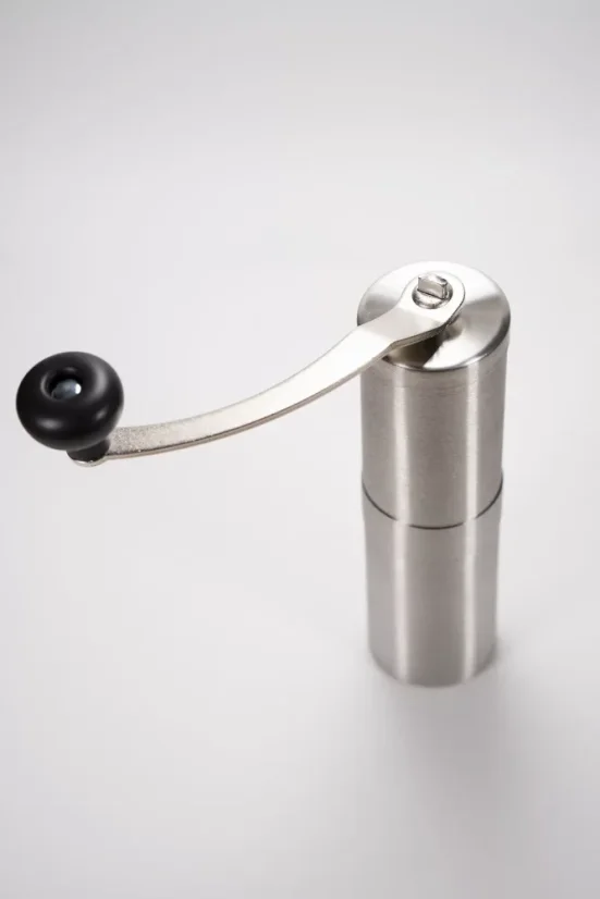 Silver manual coffee grinder on a white background, top view.