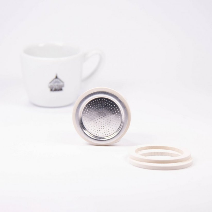 Bialetti moka kanvica tesnenie 1 hliník - 3 tesnenia + 1 sitko v pozadí s kúpeľovou kávou.