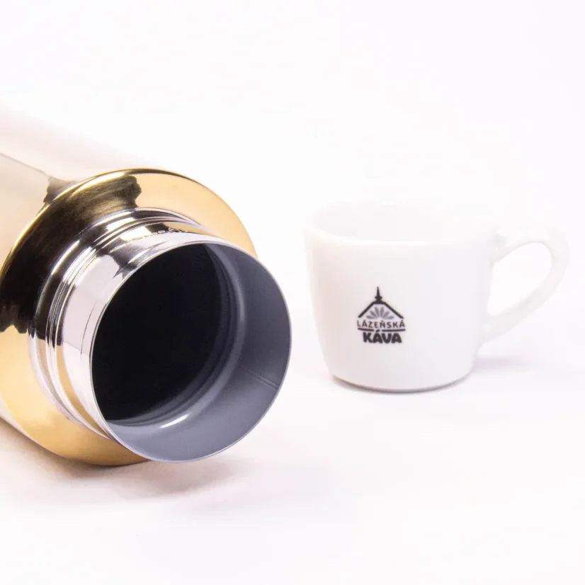 Detail of the thermos body with coffee in the background.
