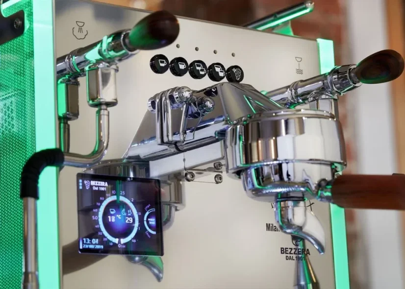 Close-up shot of the coffee machine's head and the green glowing side panels.