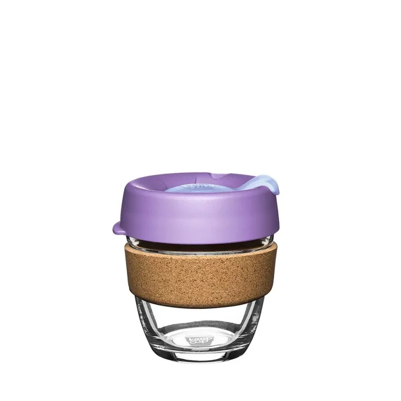 Mug en verre pour café avec couvercle violet et support en liège.