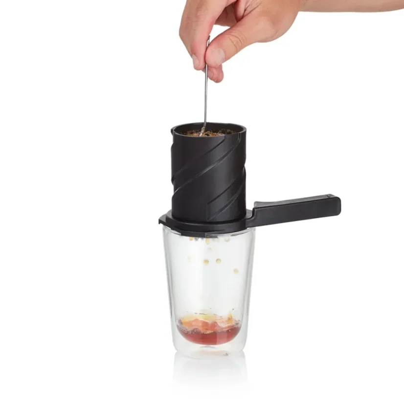 Schritt der Kaffeezubereitung mit dem Twist Press Coffee Maker 2.0 Black Barista und CO, wo der Barista den Kaffee im Handfilter umrührt.