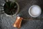 Copper coffee pot, a flower in a pot, and a bowl of sugar on a woven placemat
