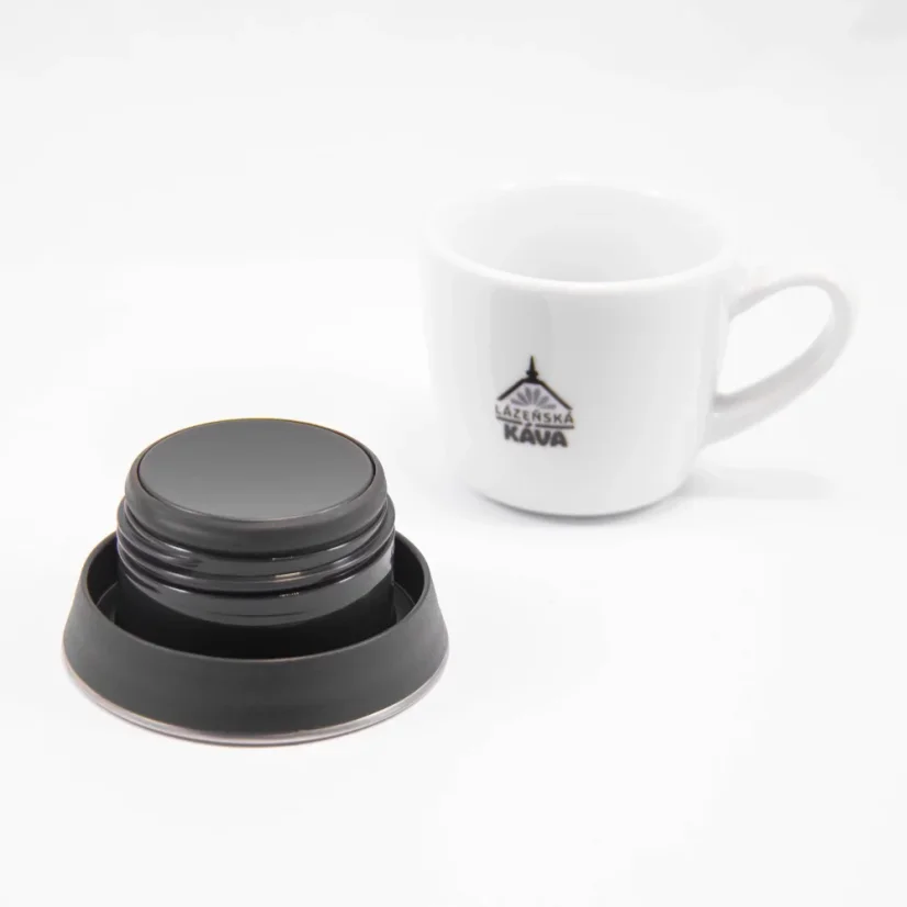 Deckel der Kinto-Thermoflasche, Ansicht der Unterseite des Deckels auf weißem Hintergrund mit einer Tasse Kaffee.