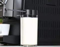 Nivona milk container next to an automatic coffee machine.