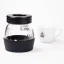 Glaskanne des Handmahlwerks Hario Skerton Pro auf weißem Hintergrund mit einer Tasse Kaffee.