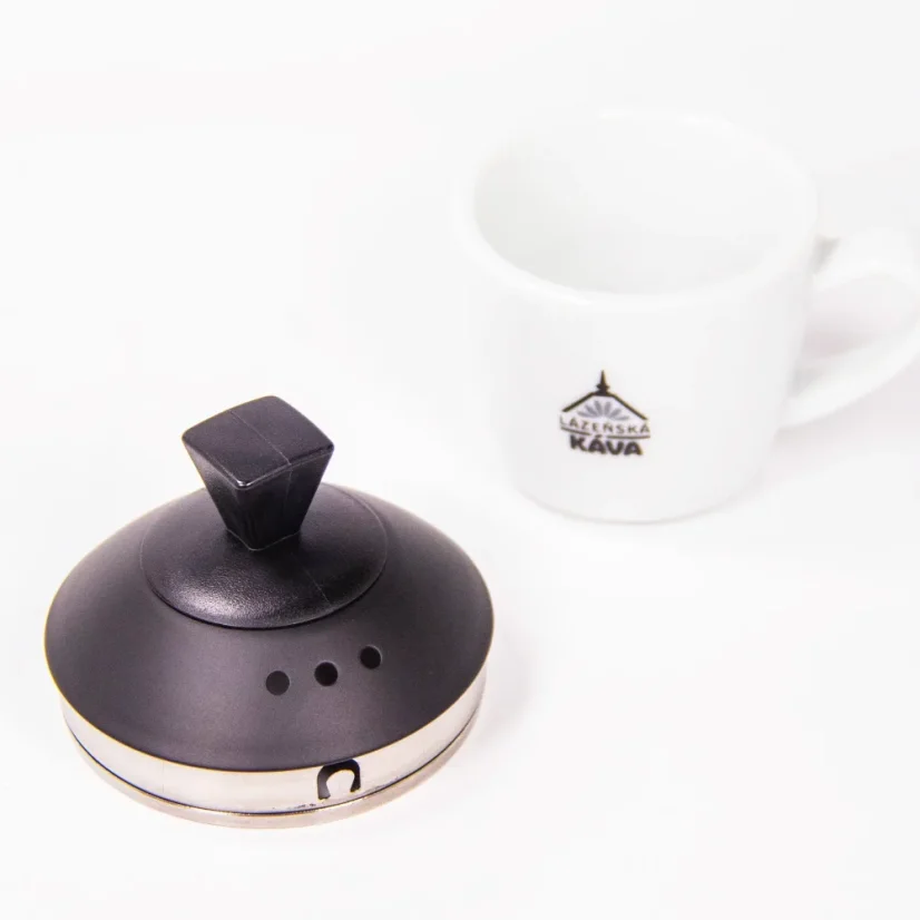 Lid from Brewista electric kettle and beside it our white coffee cup