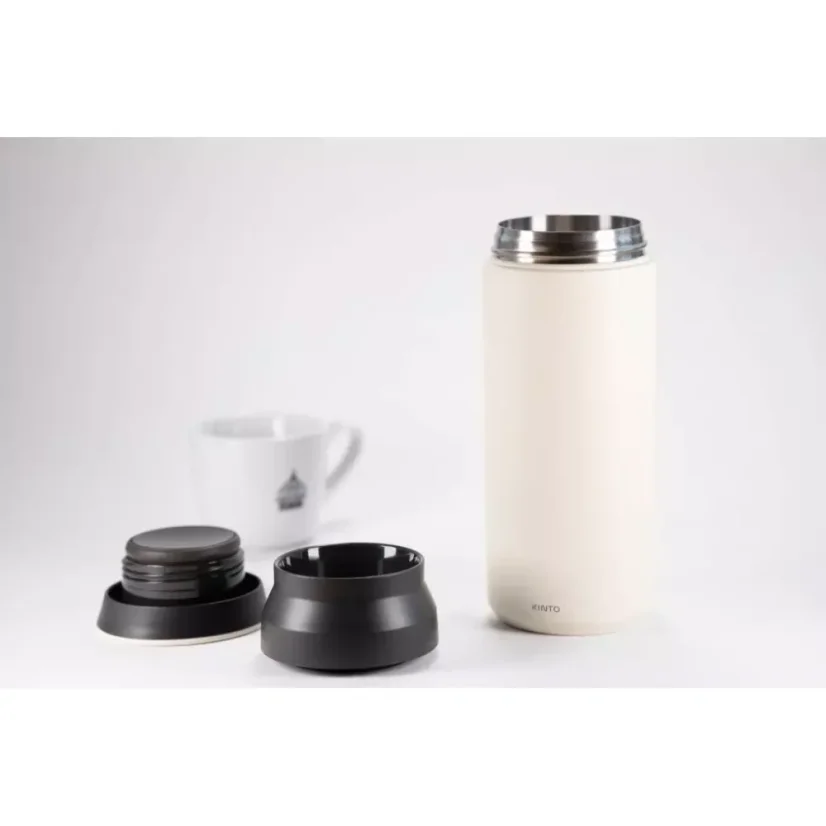 Gourde thermique blanche en acier inoxydable de 500 ml avec couvercle démonté sur un fond blanc avec une tasse de café.