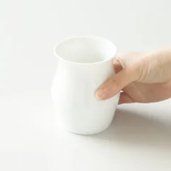 Taza Sensory Cup blanca en la mano.