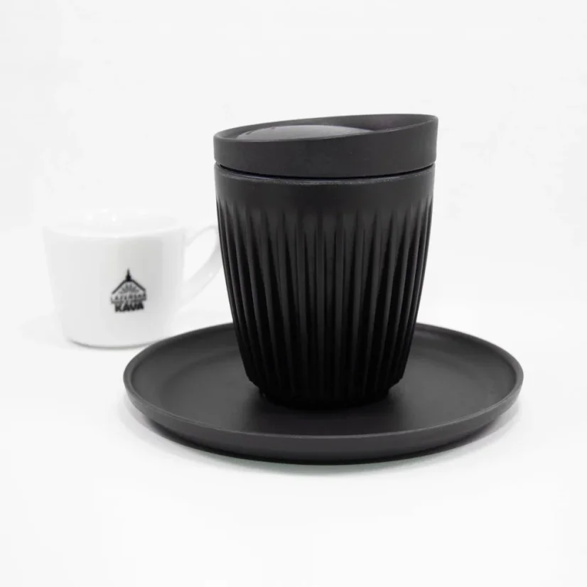 Čierny ekologický termohrnček s viečkom a podšálkom s objemom 180 ml na bielom pozadí s hrnčekom kávy.