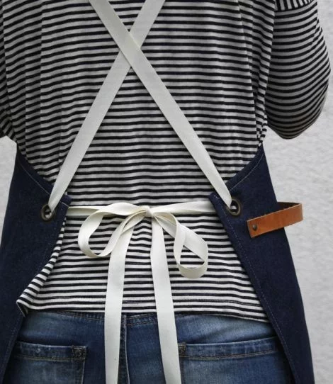 Baristische Schürze in Jeansblau mit Modell, detaillierte Ansicht der Rückenschnürung.
