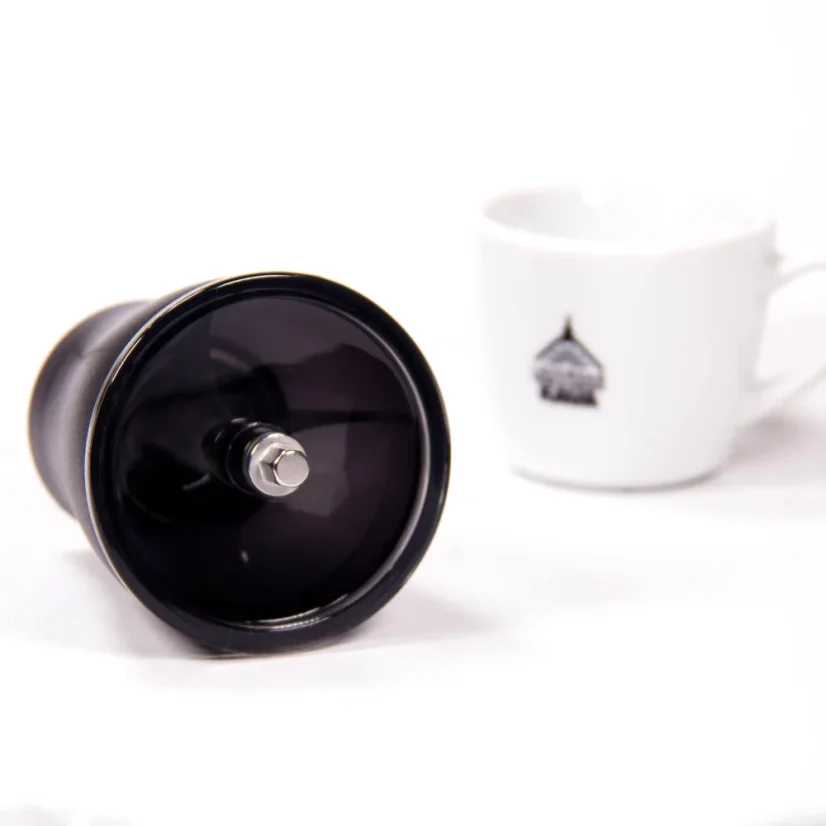 Close-up of the top hopper of the Hario Skerton Pro manual coffee grinder, accompanied by a cup.