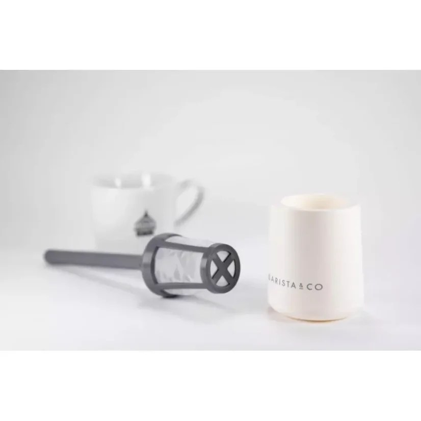 Tamis plastique facilement démontable en blanc avec en arrière-plan une tasse avec un logo.