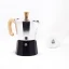 Moka pot with a wooden handle and black water funnel by Forever Miss Moka Woody for 3 servings of coffee with a cup in the background.