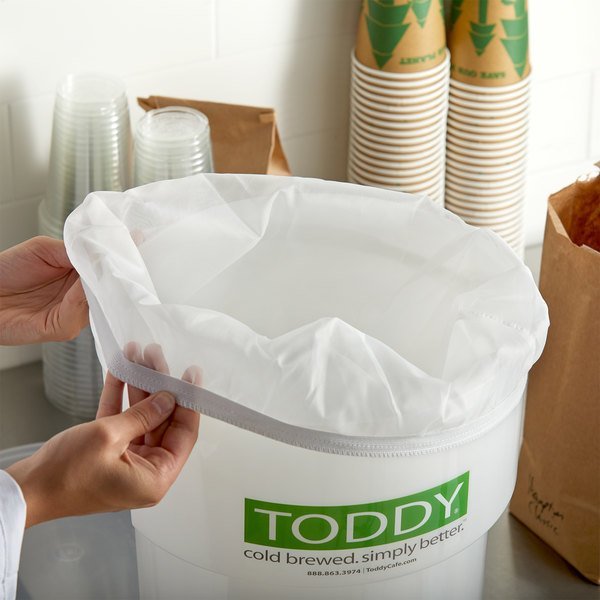 Putting a paper filter on the Toddy for making cold coffee.