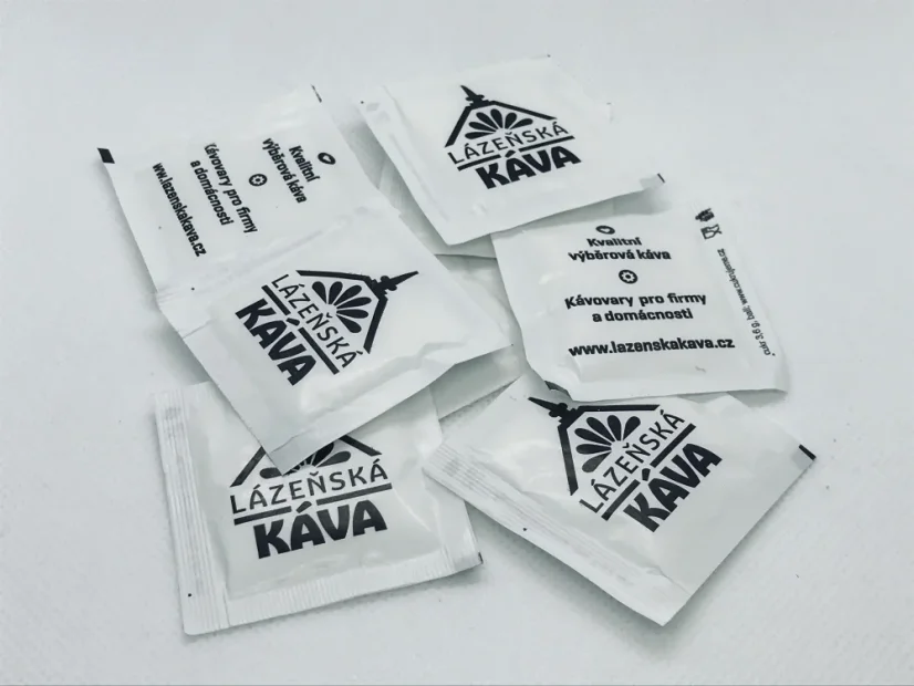 Paquetes de azúcar blanco con logo.