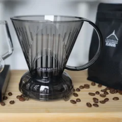 Szary plastikowy dripper na drewnianym stole, ziarna kawy i opakowanie kawy z logo. Szary plastikowy dripper na drewnianym stole, ziarna kawy i opakowanie kawy z logo.