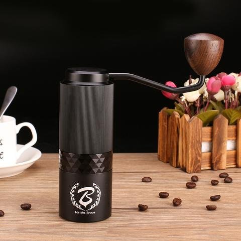 Hand grinder Barista Space Premium black on the table with coffee and cup