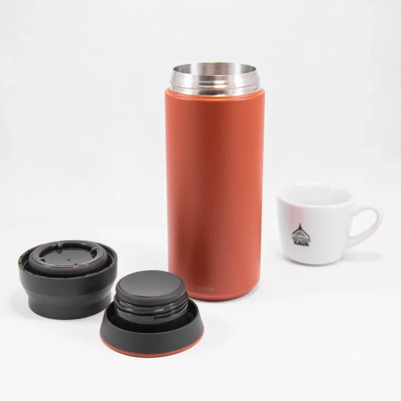 Gourde thermos en acier inoxydable rouge de 500 ml avec couvercle démonté sur un fond blanc avec une tasse de café.