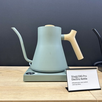 The Fellow Stagg EKG electric kettle in green color with a wooden handle offers a practical keep-warm function for perfect brewing of your favorite beverages.