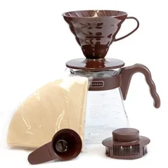 Szett a V60-os kávé elkészítéséhez Hario márkától, barna színben, papírszűrőkkel, barna kávékanállal, barna csepptartóval és fedéllel a üvegkancsóhoz. Szett a V60-os kávé elkészítéséhez Hario márkától, barna színben, papírszűrőkkel, barna kávékanállal, barna csepptartóval és fedéllel a üvegkancsóhoz.