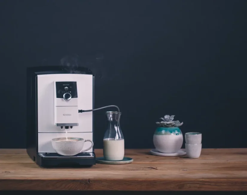 Automatischer Kaffeevollautomat Nivona 796 mit Milchbehälter und zubereitetem Cappuccino