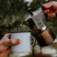 Verser du café d'une cafetière Bialetti Moka Express dans une tasse en métal.