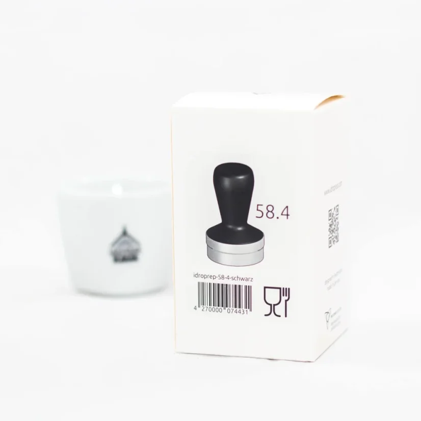 Balení eines Idroprep Tampers mit Kaffee im Hintergrund.