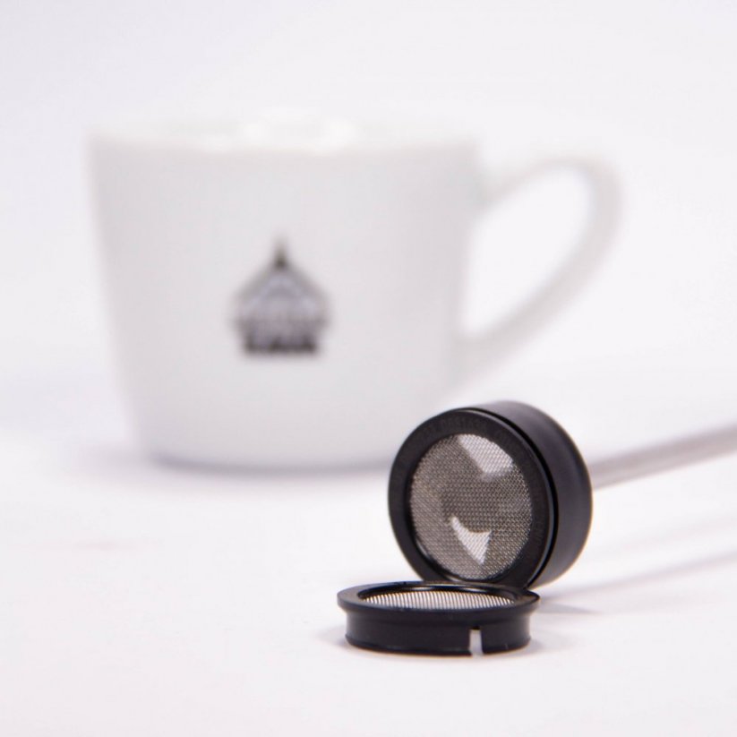 Detail of the tip of the frother. In the background a cup with the logo of Spa Coffee