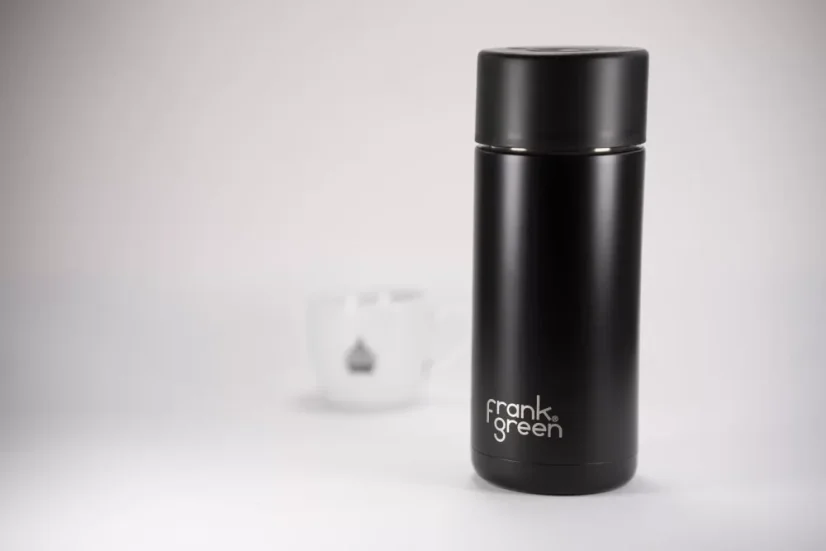 Black ceramic thermos by Frank Green with a capacity of 475 ml and a cup of coffee
