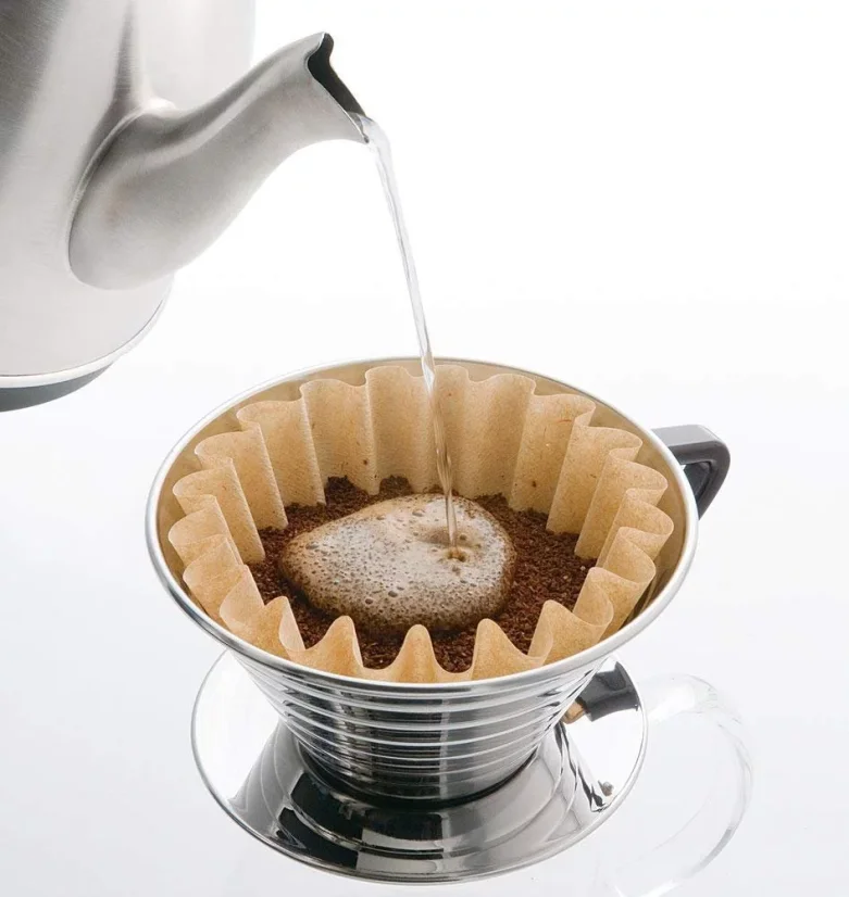 Pouring water over coffee in a paper filter and Kalita Wave 185 dripper.
