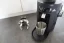 Black Mahlkonig X54 with a coffee dispenser and mounting.