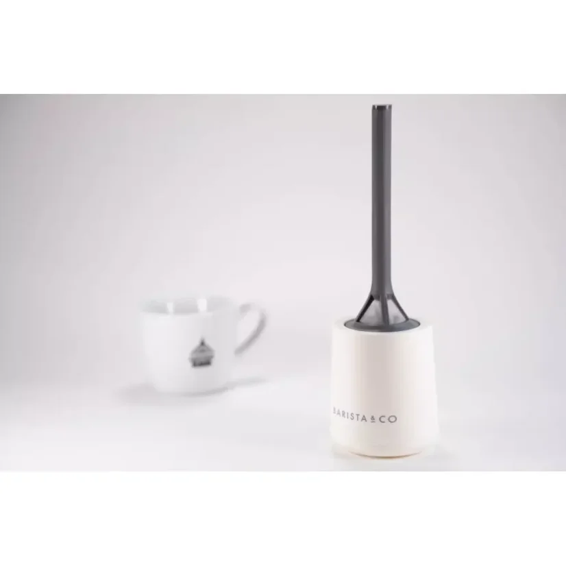 Passoire en plastique facilement démontable en blanc, avec en arrière-plan une tasse à café avec un logo.