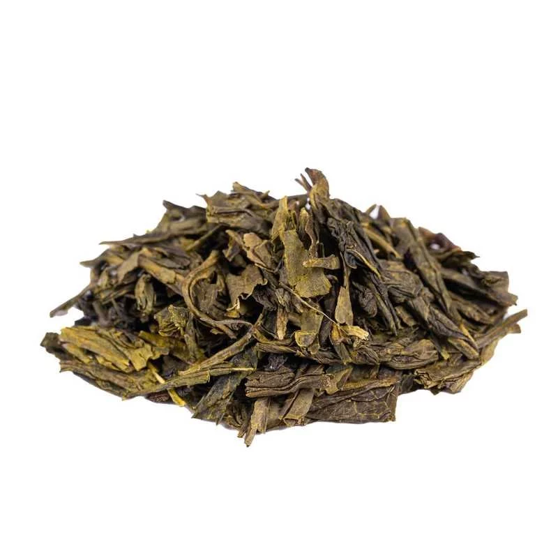 Spilled green tea China Sencha on a white background, side view