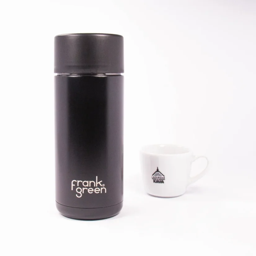 Ceramic thermos flask from the front with coffee in the background