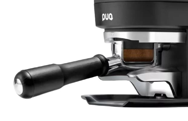 Portafilter with a compressed coffee puck in the Puqpress M3 tamper