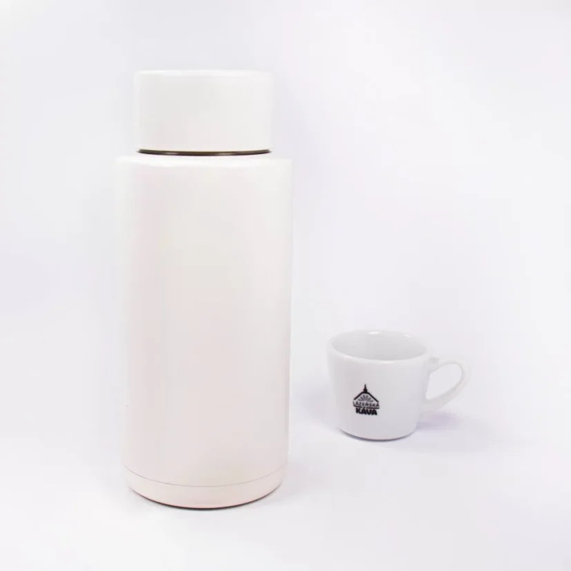 Ceramic thermos from the back with coffee in the background.
