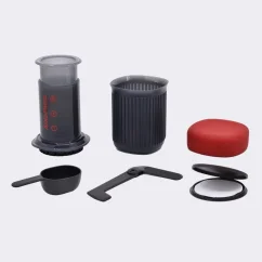 AeroPress Go cu volum de 240 ml descompus în componente pe un fundal alb