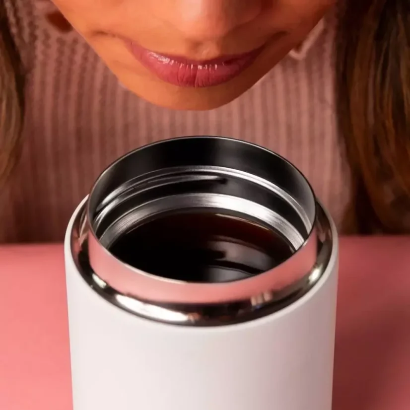 Coffee in a white travel mug by Fellow.