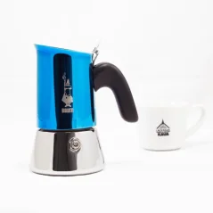 Bialetti New Venus v modrej farbe pre 2 šálky kávy s kávou v pozadí.