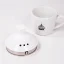 Gros plan sur le couvercle d'une bouilloire électrique Brewista à côté de notre tasse avec logo. Gros plan sur le couvercle d'une bouilloire électrique Brewista à côté de notre tasse avec logo.